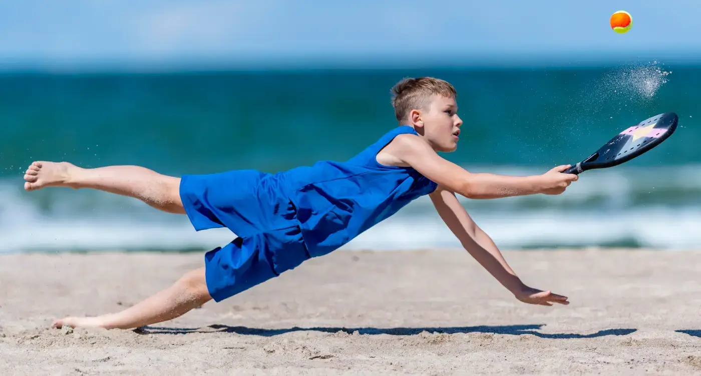 Kid Playing Badminton on the Beach