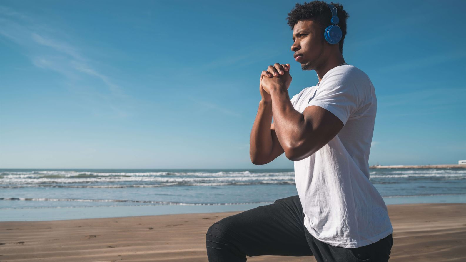 Athletic Man Doing Exercises at the Beach