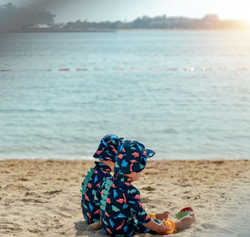 Two Babies Sit on the Beach