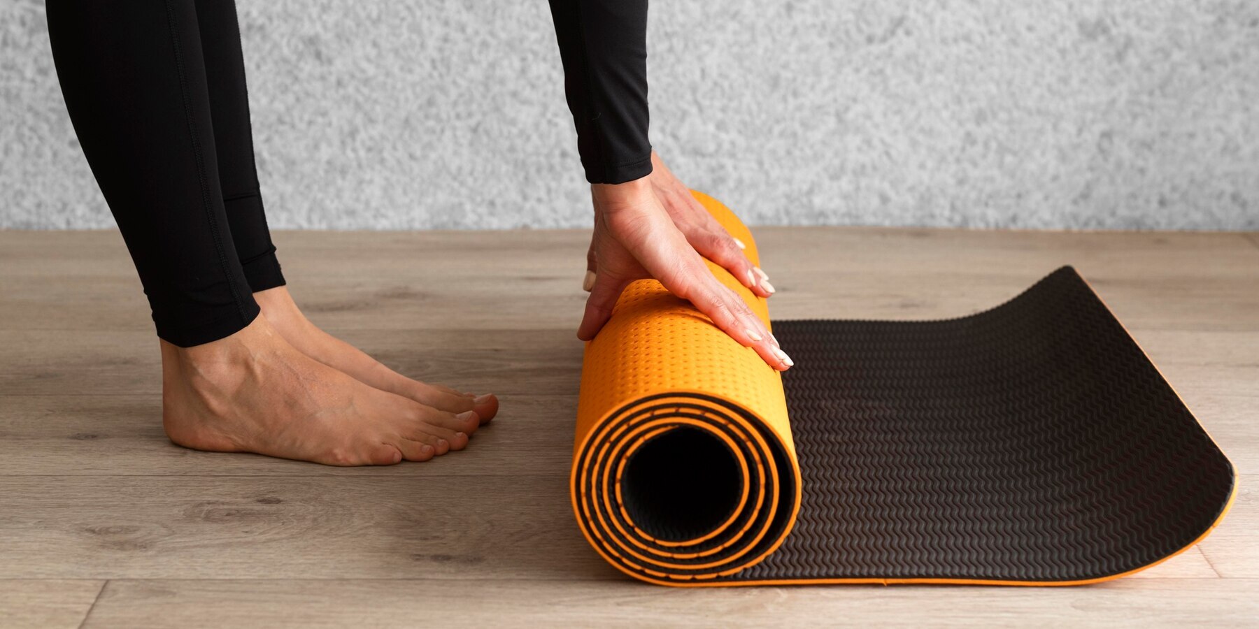 A Woman Rolling Yoga Mat